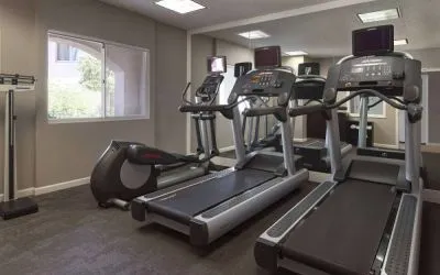 Sonesta ES Suites Tempe’s fitness center has a window, mirrored wall, treadmills, and an elliptical machine.