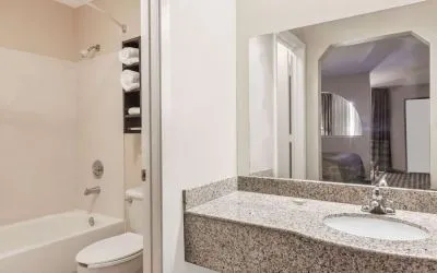 Guest bathroom with shower and bath at Super 8 By Wyndham Houston/Webster.