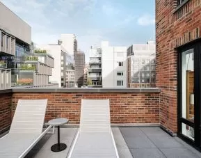 Outdoor terrace with lounge chairs at Arlo SoHo.
