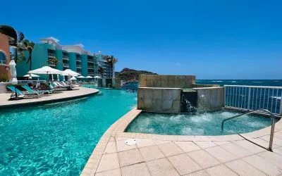 Glistening pool during daytime alongside jacuzzi hot tub at Oyster Bay Resort in St. Maarten.