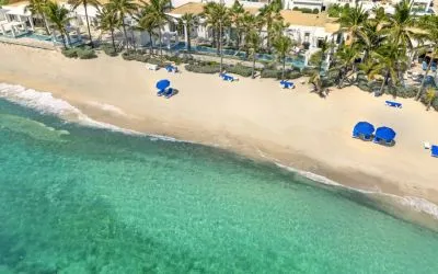 Oyster Bay Resort's beach with sun tanning chairs and waves going on shore. 