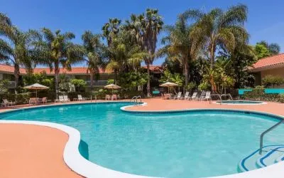 Outdoor pool with palm trees at Uptown Oasis San Jose Airport.