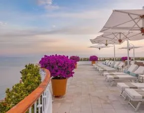 Outdoor terrace with pool chairs at Grand Miramar All Luxury Suites & Residences.