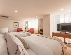 Romantic king room with natural light at Suites Perisur Furnished Apartments.