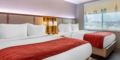 Twin bedroom with natural light at Comfort Inn JFK Airport.