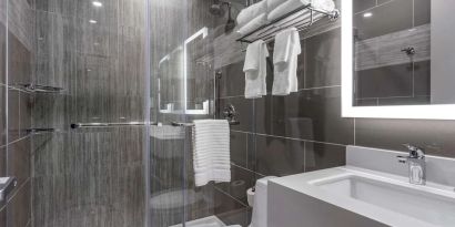 Guest bathroom with shower at Comfort Inn JFK Airport.