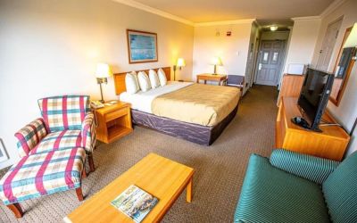 Spacious king room with lounge area at Coratel Inn And Suites By Jasper Ocean Shores.