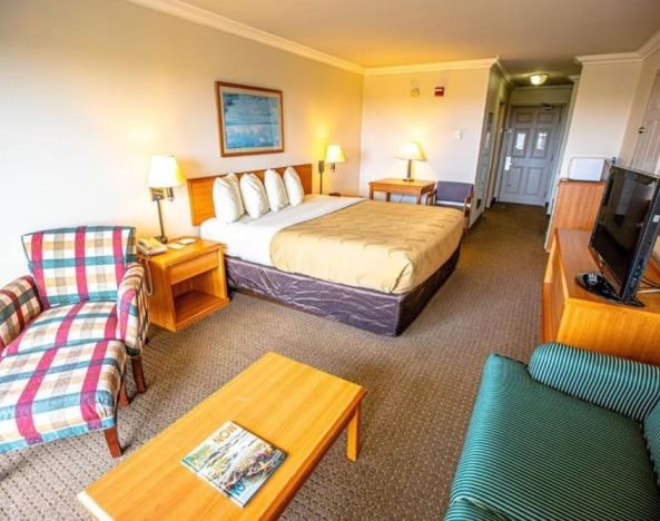 Spacious king room with lounge area at Coratel Inn And Suites By Jasper Ocean Shores.