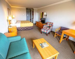 Spacious king room with TV and lounge area at Coratel Inn And Suites By Jasper Ocean Shores.