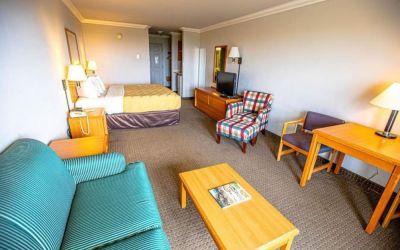 Spacious king room with TV and lounge area at Coratel Inn And Suites By Jasper Ocean Shores.