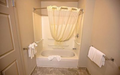 Guest bathroom with shower and bath at Coratel Inn And Suites By Jasper Ocean Shores.