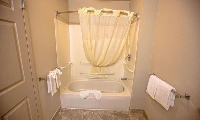 Guest bathroom with shower and bath at Coratel Inn And Suites By Jasper Ocean Shores.