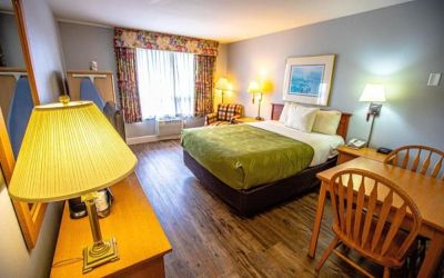 Romantic king room with seating area at Coratel Inn And Suites By Jasper Ocean Shores.
