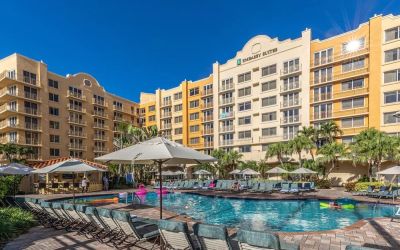 Stunning outdoor pool with loungers and umbrellas at Embassy Suites By Hilton Deerfield Beach Resort & Spa.