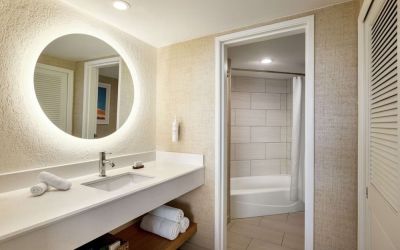 Guest bathroom with shower at Embassy Suites By Hilton Deerfield Beach Resort & Spa.