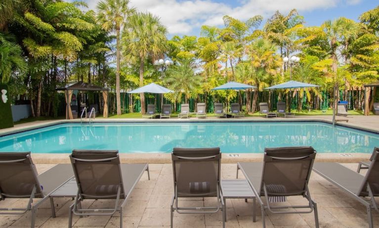 Outdoor pool with loungers at Regency Miami Airport By Sonesta.
