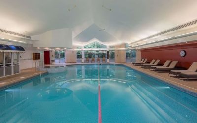 Indoor pool with lounge chairs at Hilton Leicester.