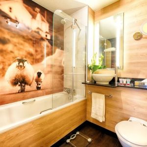 Guest bathroom with shower and tub at Leonardo Royal Hotel Edinburgh Haymarket. 