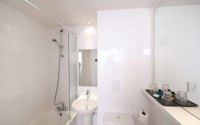 Guest bathroom with shower at Leonardo Inn Glasgow West End. 