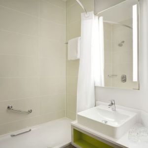 Guest bathroom with shower and tub at Leonardo Hotel Manchester Central.