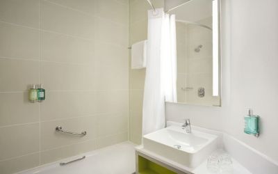 Guest bathroom with shower and tub at Leonardo Hotel Manchester Central.