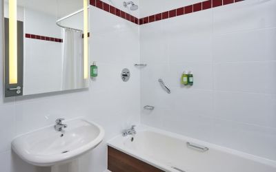 Guest bathroom with shower and tub at Leonardo Hotel Milton Keynes.