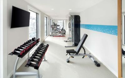 Bright fitness center with machines and equipment at the Hampton by Hilton London Docklands.