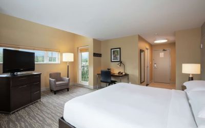 King bed with TV, terrace, workdesk and private bathroom at Hilton Whistler Resort & Spa.