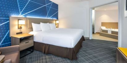 Day use king suite with comfortable bed, sofa and private bathroom with tub at Comfort Inn & Suites Barrie. 
