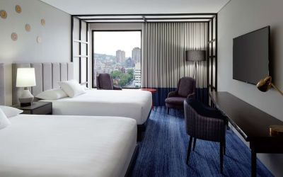 Twin day use room with work desk, lounge area and window view at DoubleTree By Hilton Montreal.