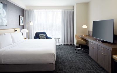 Day use room with king bed, TV, work desk and lounge area at Hilton Garden Inn Montreal Midtown.