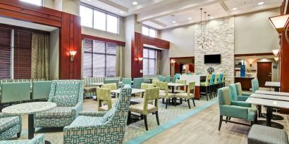 Hotel lounge and dining area with comfortable seating at the  Hampton Inn & Suites By Hilton Guelph.
