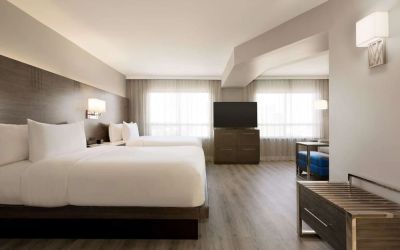 Day use twin room with TV screen, lounge area and work space at the Embassy Suites By Hilton Toronto Airport.