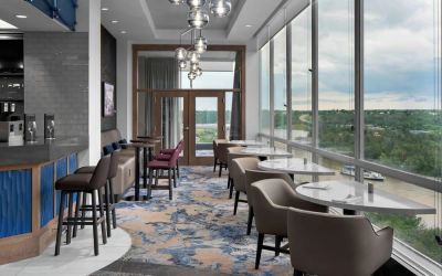 Bar lounge with large windows and comfortable chairs at Courtyard By Marriott Edmonton Downtown.