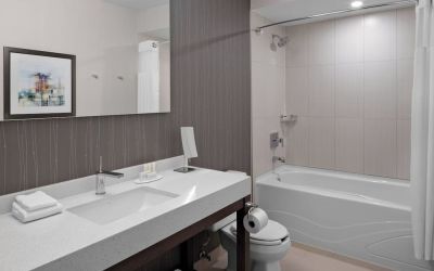 Private guest bathroom with tub and free toiletries at Courtyard By Marriott Edmonton Downtown.