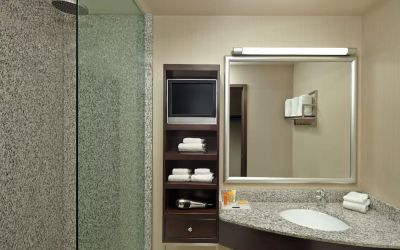 Guest bathroom with shower and free toiletries at Acclaim Hotel Calgary Airport.