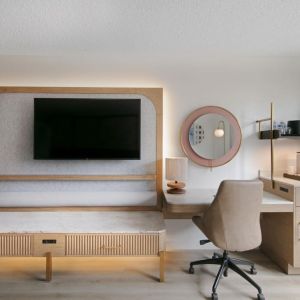 Day use room's workspace with TV screen and workdesk with ergonomic chair at Sonesta Miami Airport.