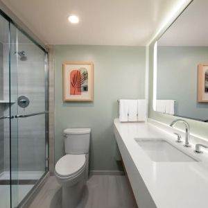 Private guest bathroom with shower and free toiletries at Sonesta Miami Airport.