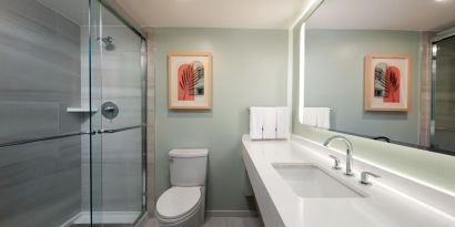 Private guest bathroom with shower and free toiletries at Sonesta Miami Airport.