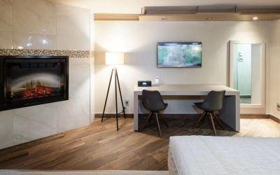 Day use room with TV, work desk, fireplace and private bathroom at Le Chabrol Hotel Et Suites.