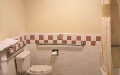 Guest bathroom with shower and tub at Scottish Inn & Suites.