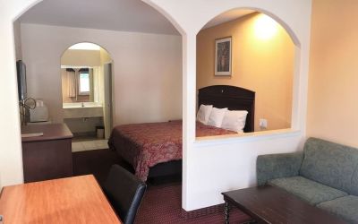 Day use room with sofa and work desk at Scottish Inn & Suites.