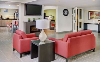 Lobby lounge with TV screen and fireplace at Comfort Inn Sault Ste. Marie.