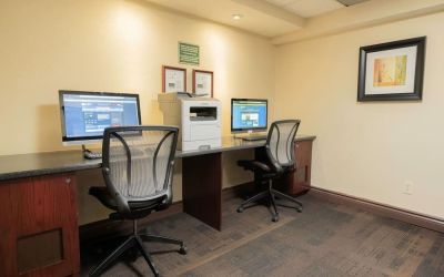 Business center with computers, printer and ergonomic chairs at Les Suites Hotel Ottawa.