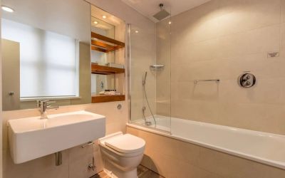 Guest bathroom with tub and free toiletries at Thistle Holborn, The Kingsley Hotel.