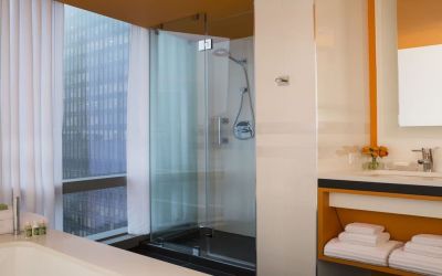 Guest bathroom with shower and tub at Courtyard By Marriott New York Manhattan/Central Park.