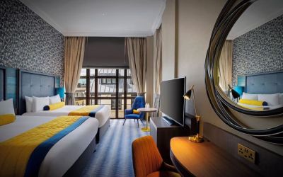 Day use twin room with TV screen, work desk and lounge seating at Leonardo Royal Hotel London City.