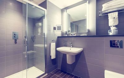 Guest bathroom with shower and free toiletries at Mercure London Paddington Hotel.