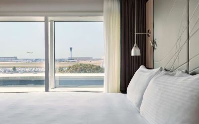 King bed with floor to ceiling window at Hyatt Place London Heathrow Airport.