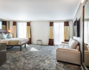 Btight and spacious king room with floor to ceiling windows, convertible sofa and work desk at Atrium Hotel Heathrow.